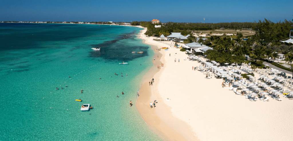 a beach with people and boats, drone shot from Seafire Residences cayman.